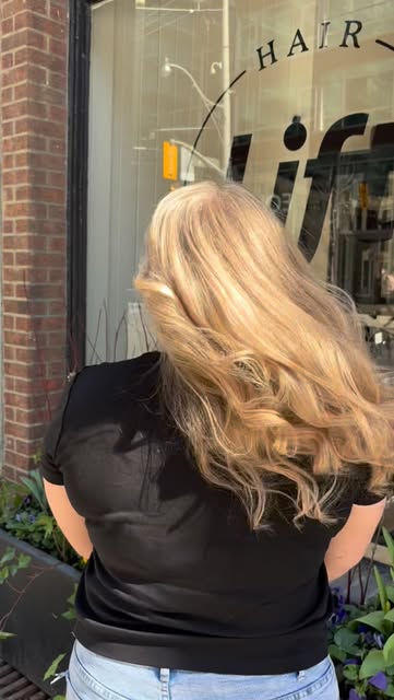Long softly curled blonde hair outside Lift Hair Studio